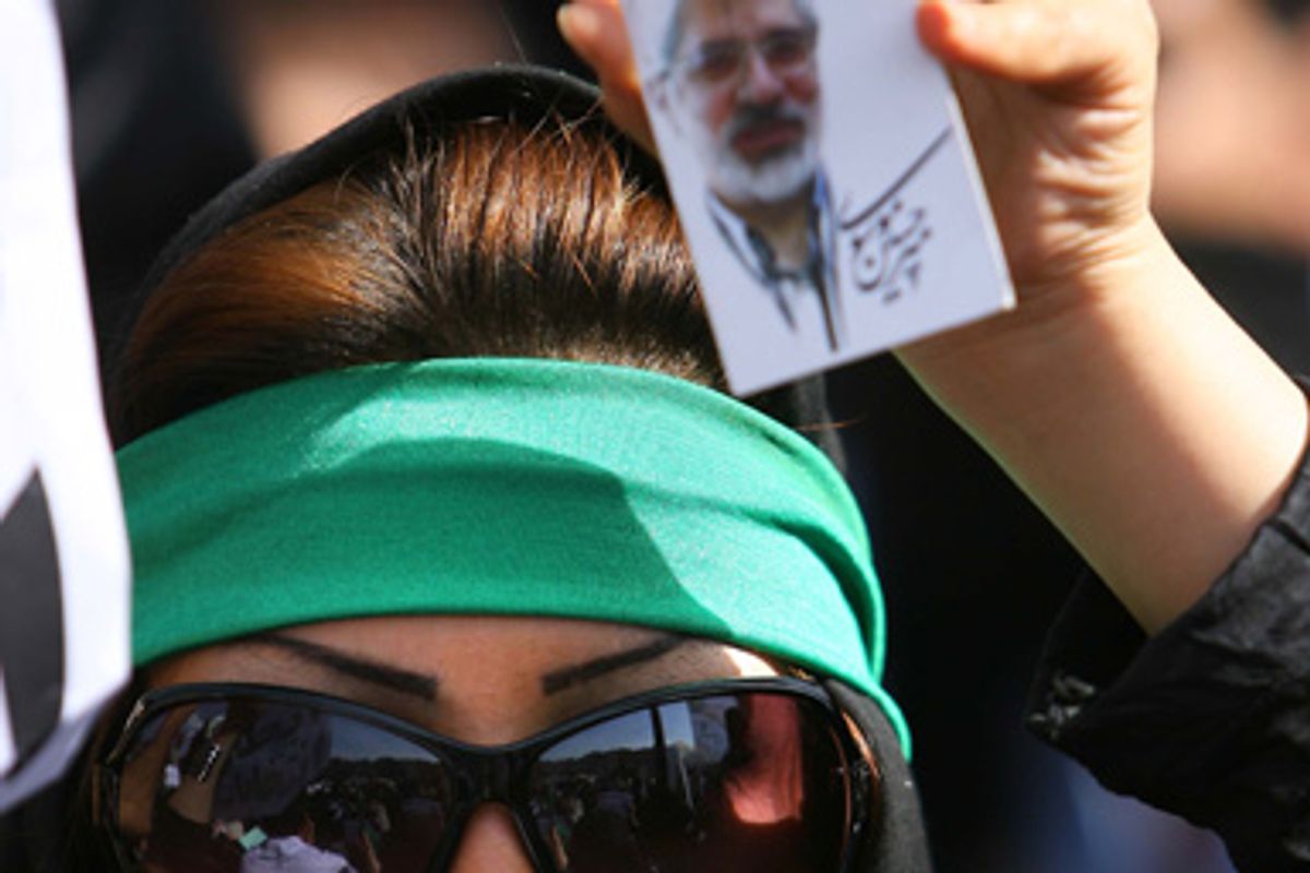 In this image made available from Mousavi's election campaign media operation Ghalam News, shows a supporter of opposition leader Mir Hossein Mousavi, as she holds his photo as she listens to his speech at a demonstration in Tehran on Thursday June, 18, 2009.