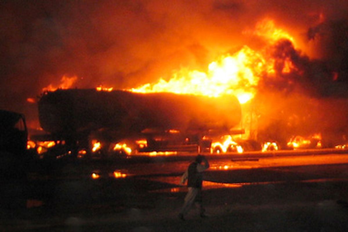 A security official walks near a burning fuel tanker, which has been standing for more than a day in gridlock along the Chaman Pakistan-Afghanistan border August 30, 2009. 