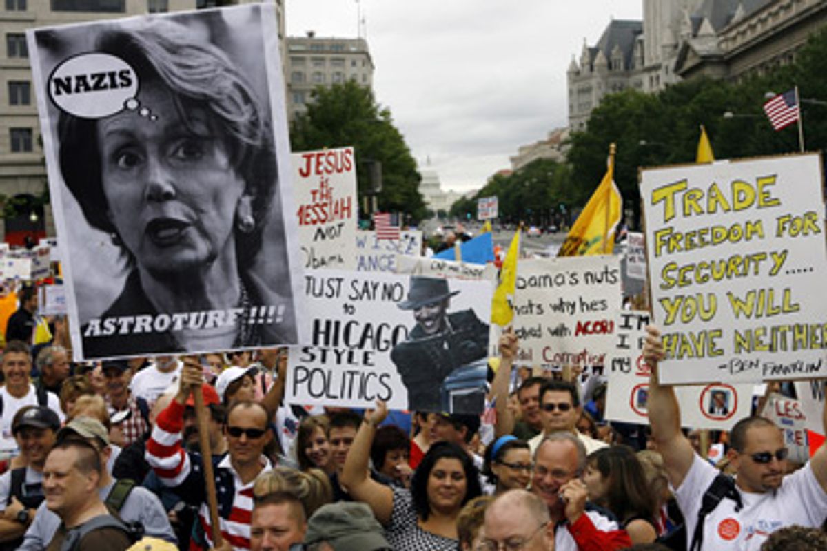 A crowd of people, some carrying signs, are shown during a rally at Freedom Plaza in Washington on Saturday, Sept. 12, 2009. 