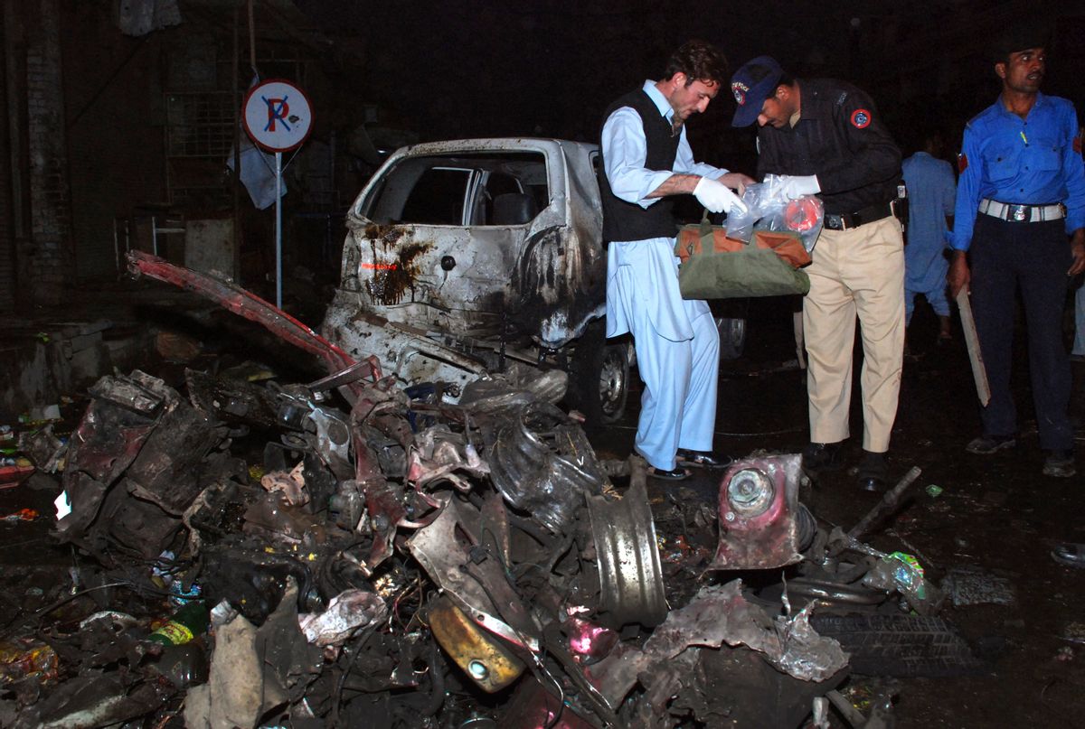 Police officials survey the site of a suicide bomb explosion in Charsadda, located about 20 km (12 miles) northeast of Peshawar November 10, 2009. Pakistani Taliban militants vowed to fight a tough, protracted guerrilla war against the army on Tuesday as a suicide car-bomber killed up to 20 people in a northwestern town, police said. A suicide bomber in a car set off explosives in a square in the centre of Charsadda killing up to 20 people and wounding at least 30, town police chief Riaz Khan said.  REUTERS/K Parvez  (PAKISTAN CONFLICT) (Reuters)