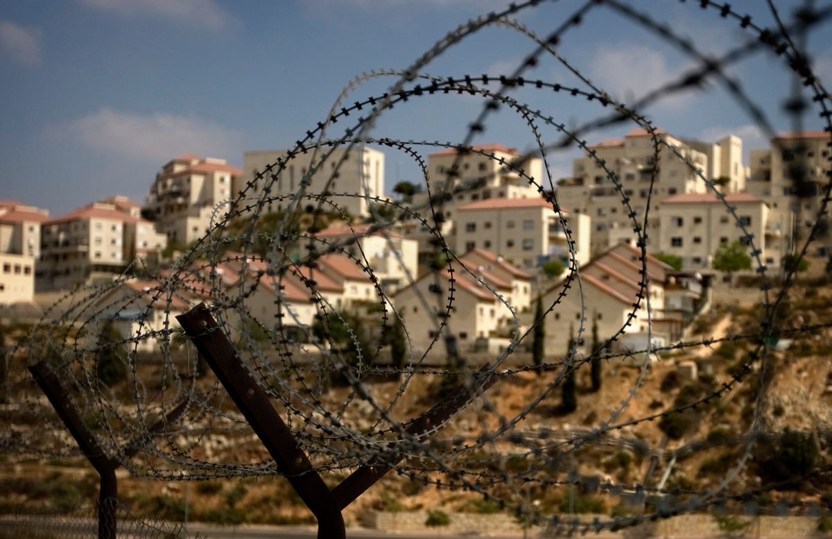 The West Bank Jewish settlement of Beitar Ilit is seen through a barbed wire fence, Friday, Sept. 4, 2009. Prime Minister Benjamin Netanyahu is expected to  approve some hundreds of new housing units in West Bank settlements before slowing settlement construction, two of his aides said Friday, in an apparent snub of Washington's public demand for a total settlement freeze.  (AP Photo/Sebastian Scheiner)   (Associated Press)