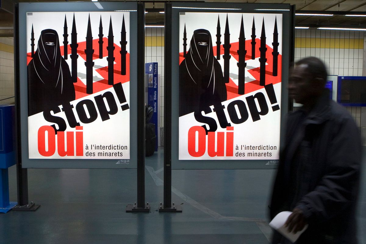 A man passes by a poster of the right-wing Swiss People's Party (SVP/UDC) which shows a woman wearing a burqa against a background of a Swiss flag upon which several minarets resemble missiles at the central station in Geneva, Switzerland, Wednesday, Nov. 4, 2009. Swiss citizens will vote on November 29 on a referendum launched by right-wing groups on whether the construction of minarets should be banned in Switzerland. (AP Photo/Keystone, Salvatore Di Nolfi) (Associated Press)