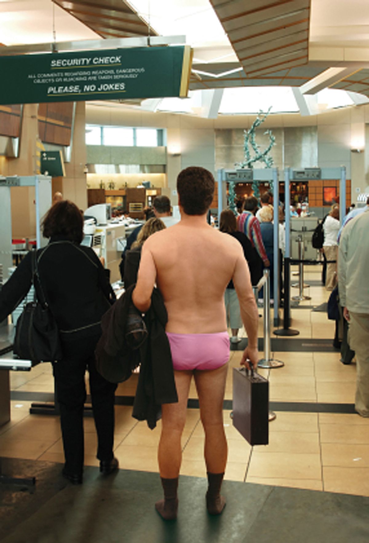 Man standing in his underwear, waiting to go through an airport security check station (James Steidl)