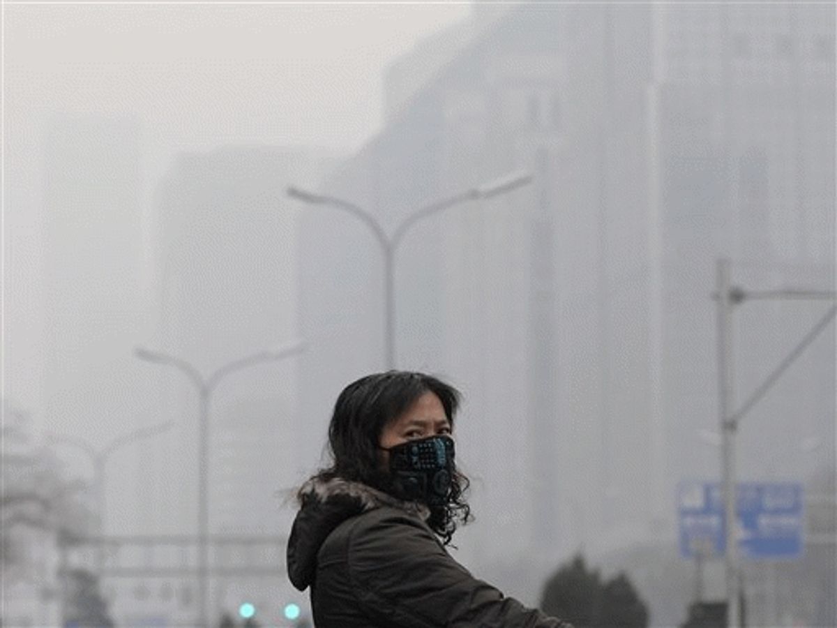 A masked woman looks away while crossing a street in the city center shrouded in fog, caused by air pollution, in Beijing Monday. Negotiators in Copenhagen are trying to set targets for controlling emissions of carbon dioxide and other global warming cases, including by the leading contributors, China and the United States. 