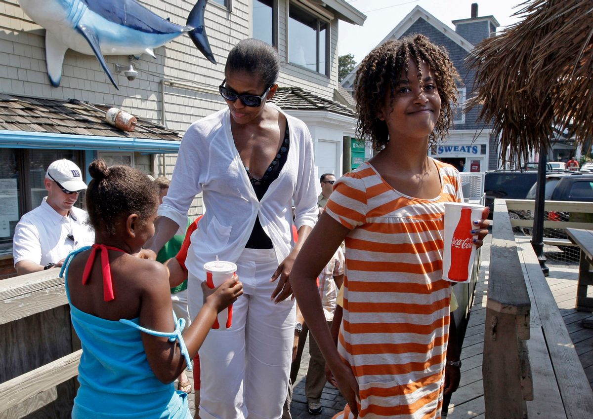 FILE - In this Aug. 26, 2009, file photo, first lady Michelle Obama walks with daughter Malia, 11, right, and Sasha, 8, while they wait to get lunch at Nancy's in Oak Bluffs, Mass., while vacationing on Martha's Vineyard. (AP Photo/Alex Brandon, File)  (Associated Press)