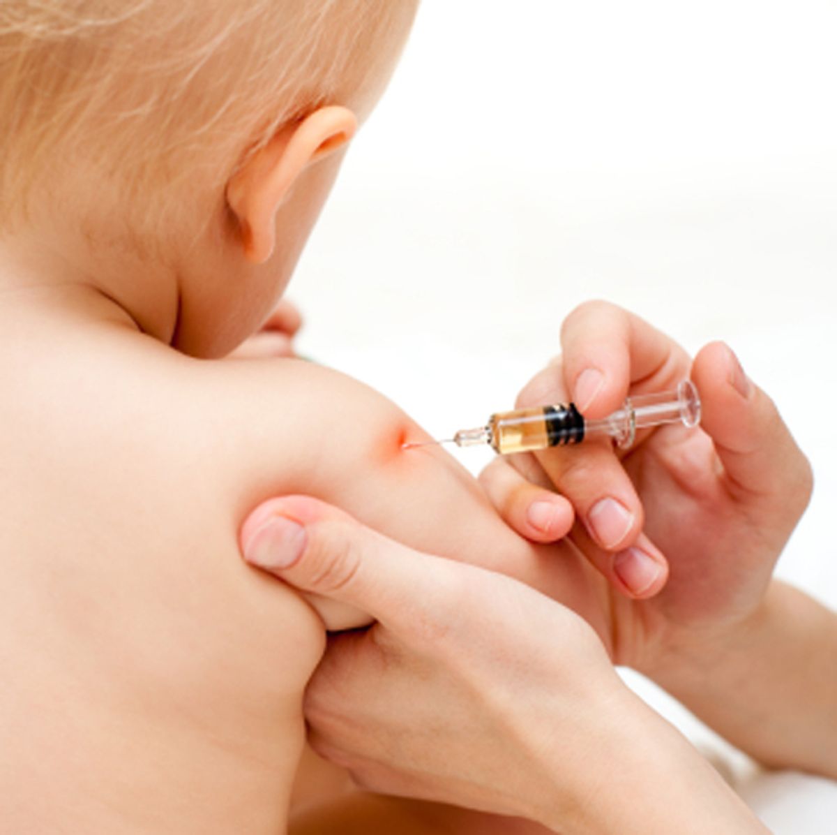 Doctor giving a child an intramuscular injection in arm, shallow DOF  (Dmitry Naumov)