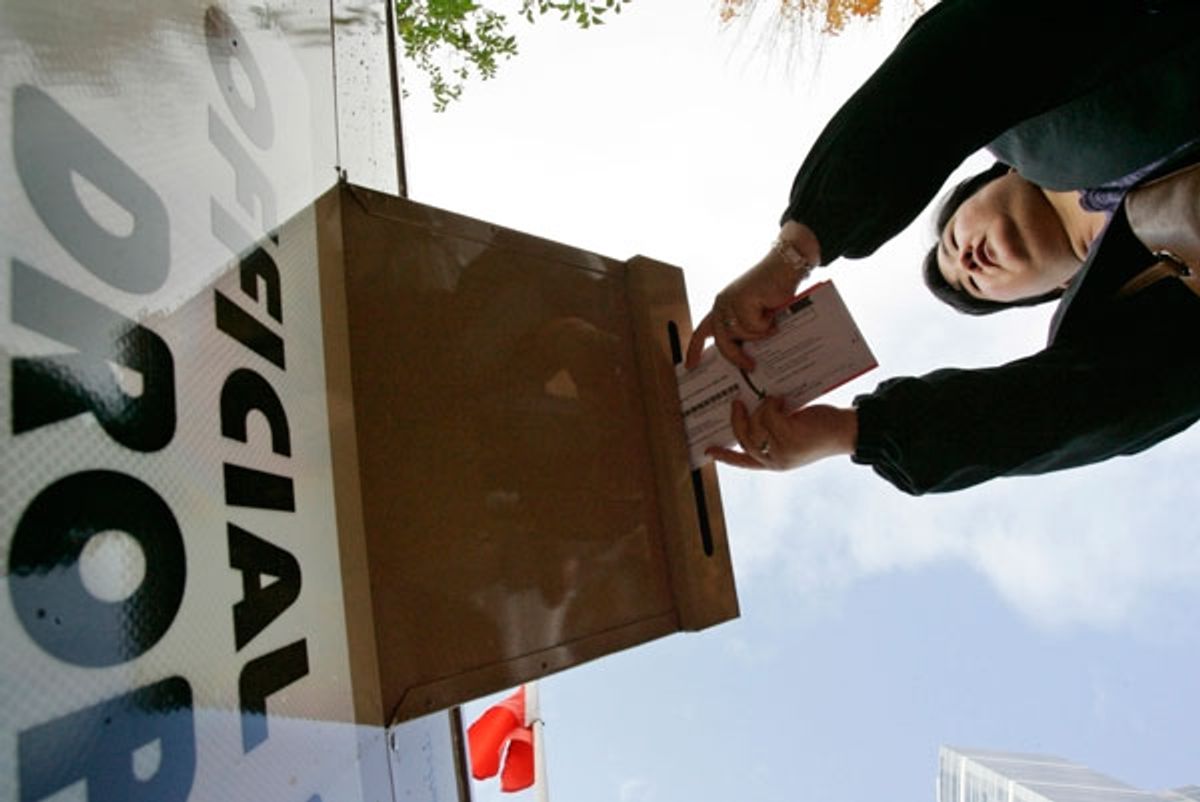 A voter drops off her election ballot at a drop box in Portland, Oregon November 4, 2008.
