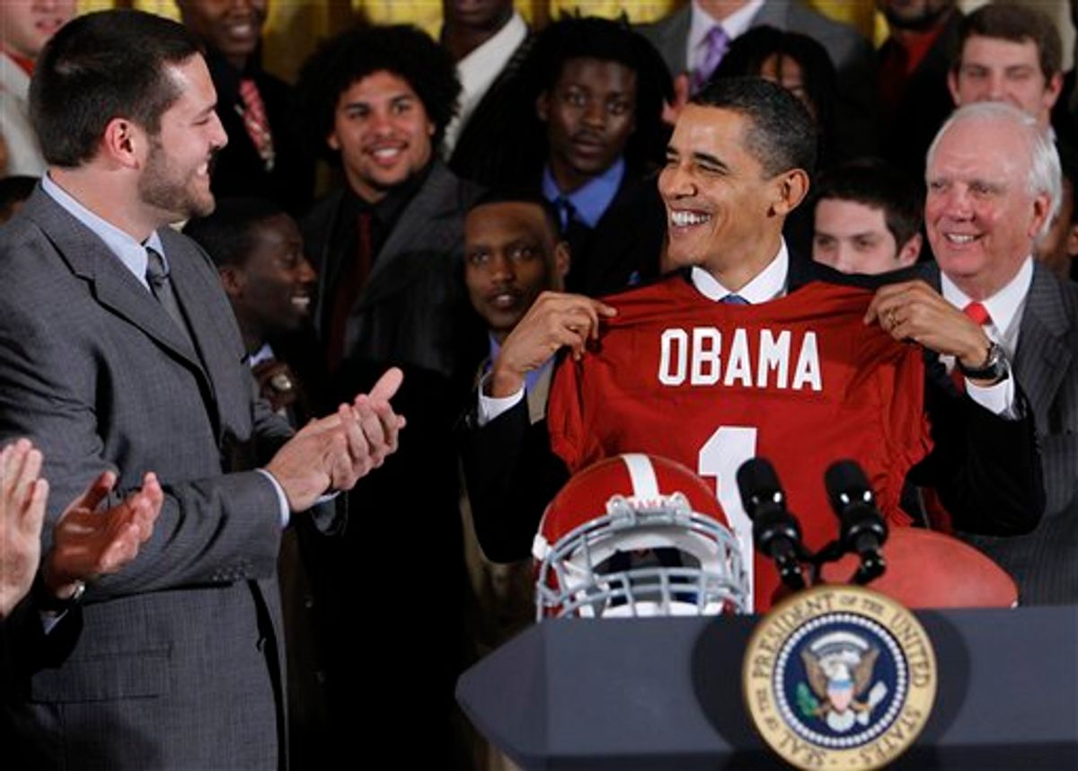 President Barack Obama smiles as he holds an University of Alabama football jersey during a ceremony honoring the BCS national champion Crimson Tide football team, Monday, March 8, 2010, in the East Room of the White House in Washington. (AP Photo/Alex Brandon) (AP)