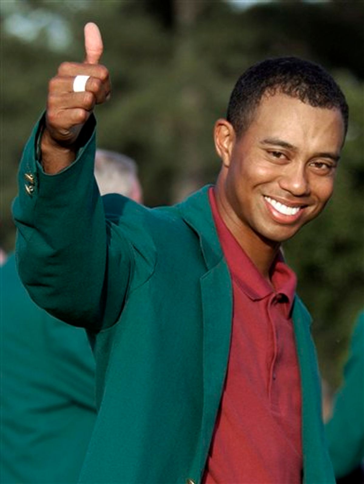 FILE - In this April 14, 2002, file photo, Tiger Woods, wearing his green jacket, gives a thumbs up as he celebrates winning the Masters golf tournament at the Augusta National Golf Club in Augusta, Ga.  In a statement Tuesday, March 16, 2010, Woods said he will play at Augusta National after a four-month hiatus because of a sex scandal. The Masters begins on April 8. (AP Photo/Elise Amendola, File) (AP)