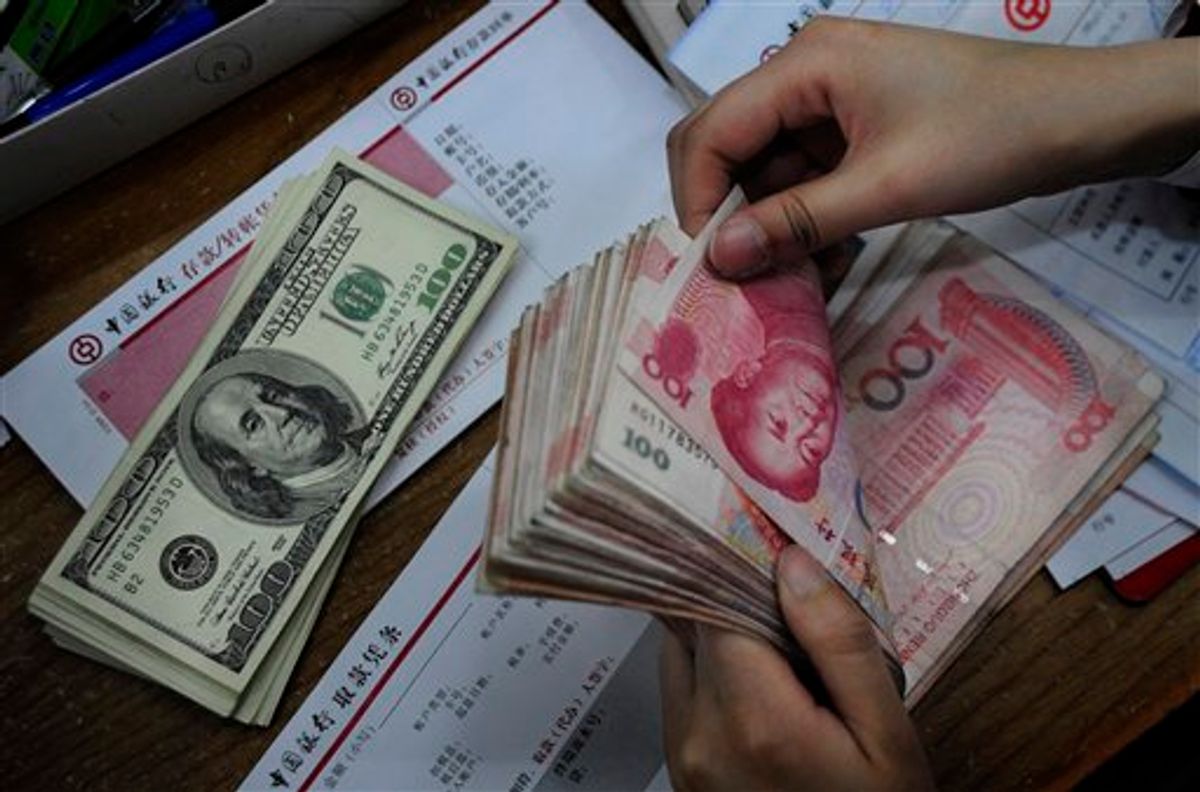In this photo taken Tuesday, April 6, 2010, a bank clerk counts Chinese banknotes next to U.S. dollars on the counter at a bank in Hefei, in central China's Anhui province. U.S. Treasury Secretary Timothy Geithner is expected to press Beijing over its currency controls when he meets Vice Premier Wang Qishan in a sign the two sides are stepping up efforts to narrow their differences in the dispute. (AP Photo) **  CHINA OUT **  (AP)