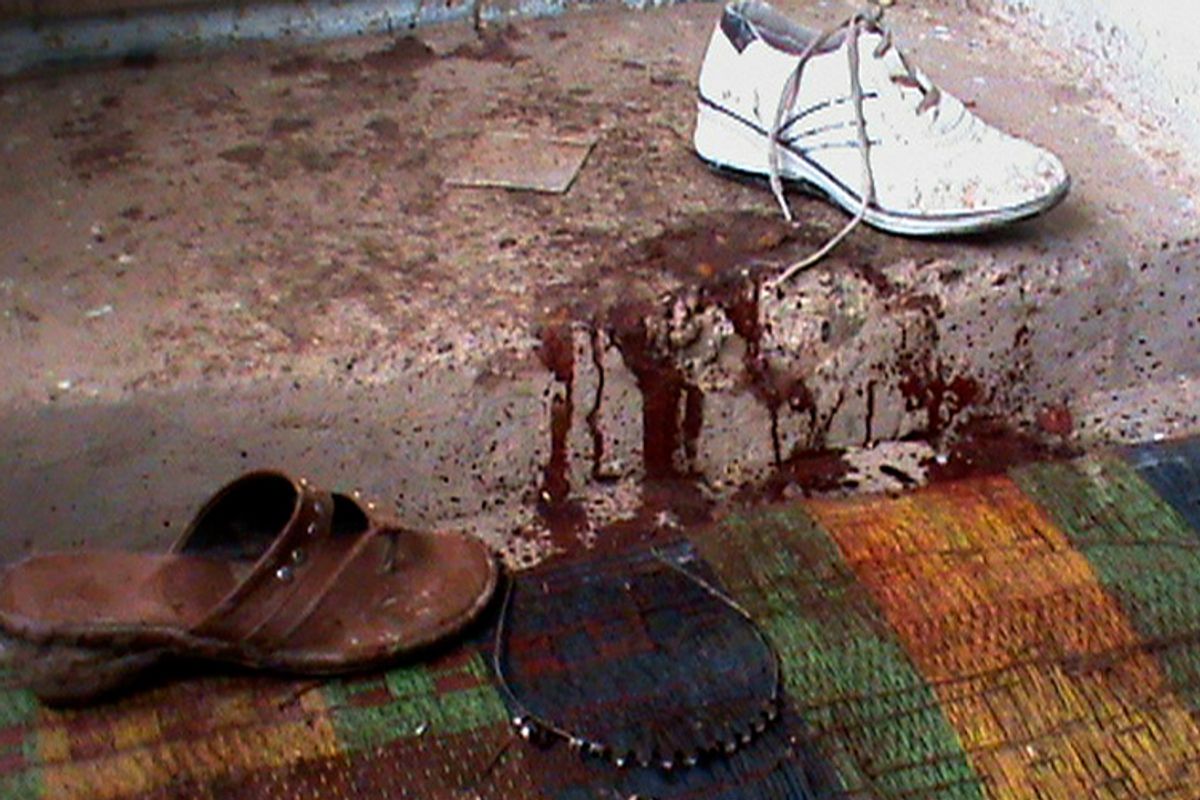 Blood is seen near a shoe and a hairband inside a room where five members of an Afghan family were killed near Gardez, in Paktia province, Friday, Feb. 12, 2010.