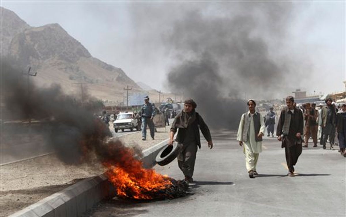 Afghan protesters burn tires to block a road during an anti-American protest in Kandahar, south of Kabul, Afghanistan, Monday, April 12, 2010. International troops opened fire on a bus carrying Afghan civilians early Monday, killing four people and setting off anti-American protests in a southern city that is a hotbed of the Taliban insurgency.(AP Photo/Allauddin Khan) (AP)