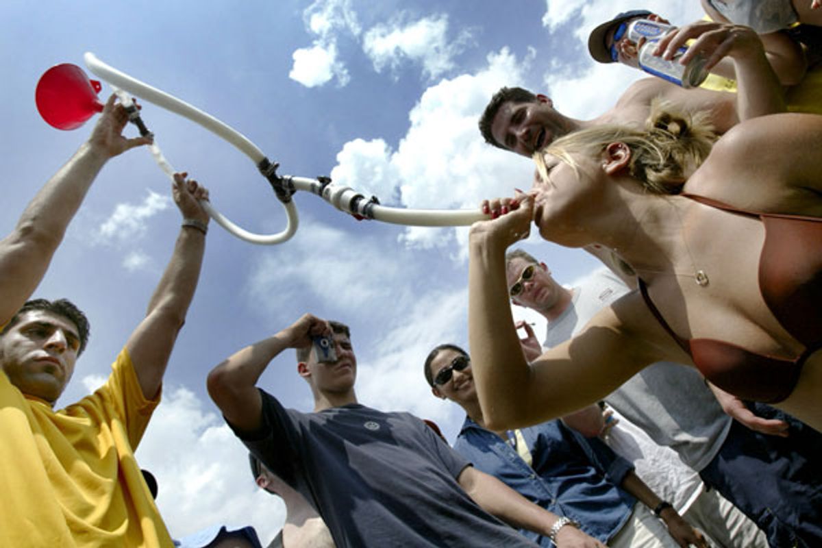 A college girl drinks beer through a funnel and pipe as thousands of college-age students gather on the infield in a traditional display of drunken fun on the day of the Preakness Stakes horse race at the Pimlico track in Baltimore, Maryland, May 15, 2004.