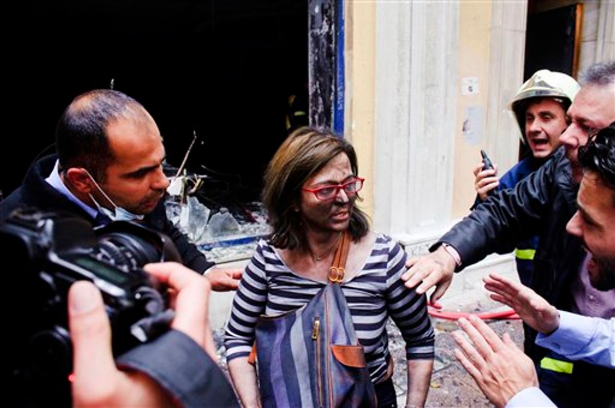A bank employee reacts after being rescued from a fire that broke out when the bank was attacked during anti-government protests in central Athens, Wednesday, May 5, 2010. Three people died in the fire at the branch of Marfin Egnatia Bank, while the two women and two others were rescued. An estimated 100,000 people took to the streets Wednesday during a nationwide wave of strikes against spending cuts aimed at saving the country from bankruptcy  (AP Photo/Iakovos Hatzistavrou) ** GREECE OUT ** (AP)