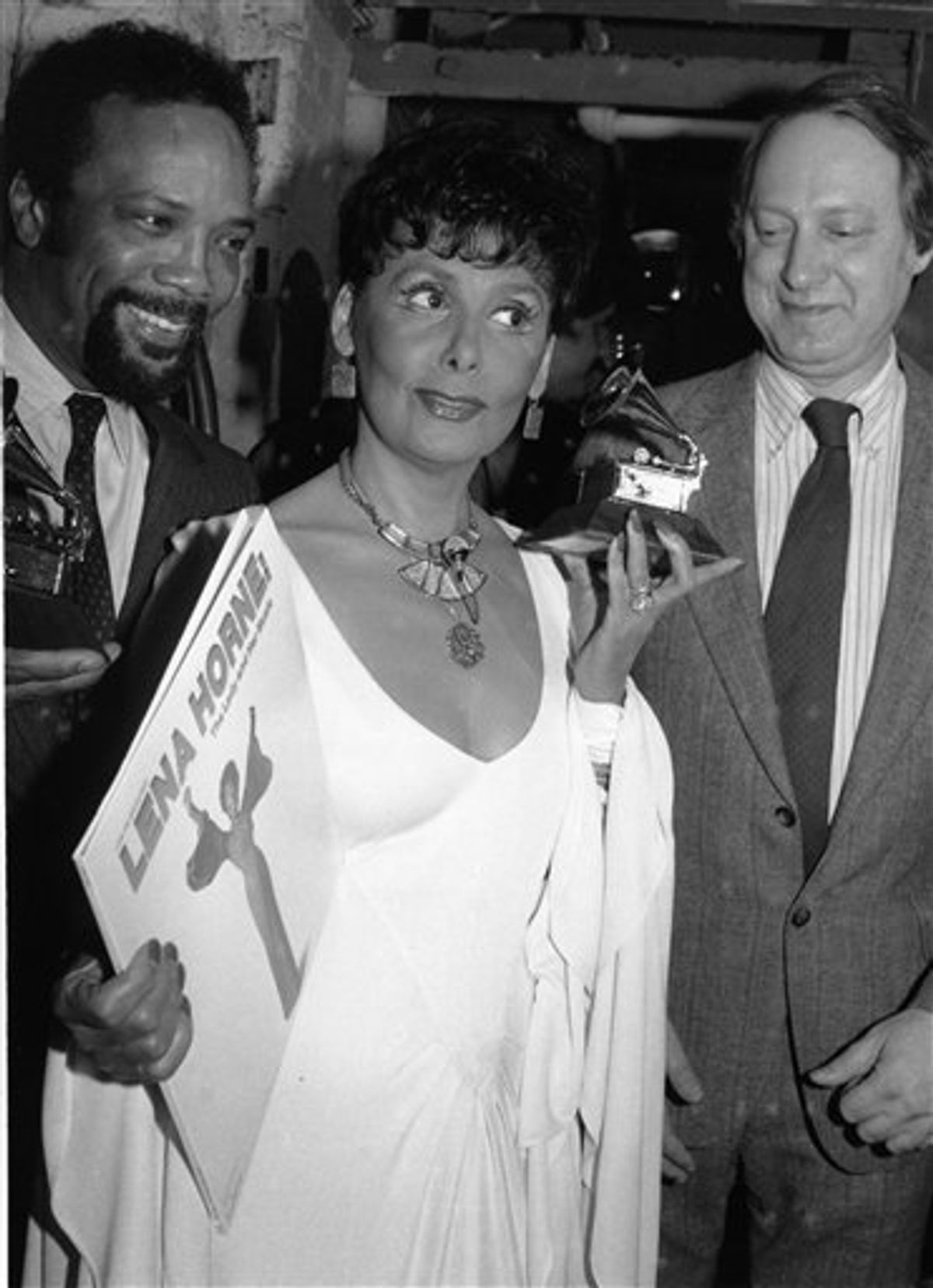FILE -- In a March 7, 1982 file photo Grammy Award winner Lena Horne, center, is flanked by record producer Quincy Jones, left, holding his Grammy, and Dan Morgenstern, of the National Academy of Recording Arts and Sciences, as she displays her award, and the record that earned it, in New York.  Singer Lena Horne, who broke racial barriers as a Hollywood and Broadway star famed for her velvety rendition of "Stormy Weather," has died at age 92.  (AP Photo/Ron Frehm/file) (AP)