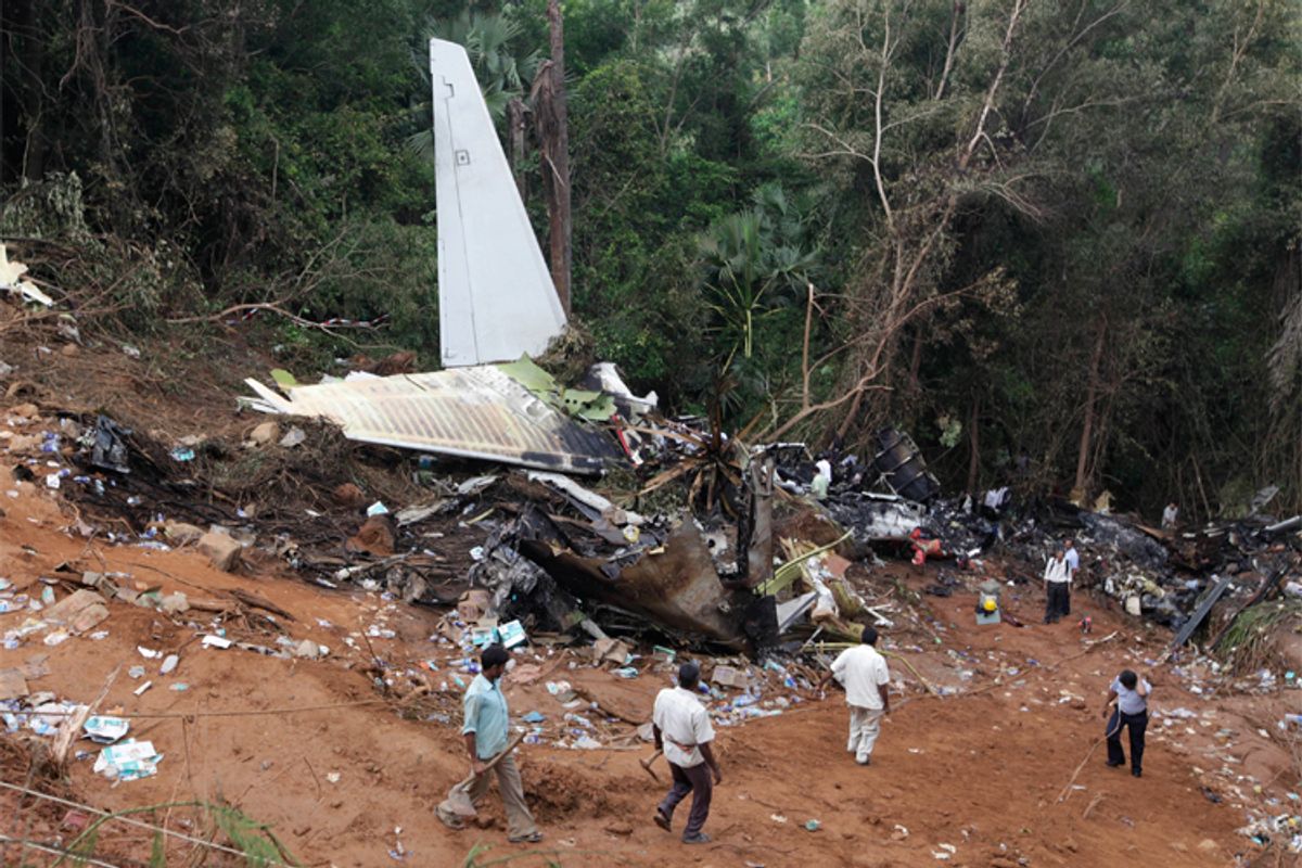 Forensic officials and rescue workers inspect the wreckage of a crashed Air India Express passenger plane in Mangalore on May 23.