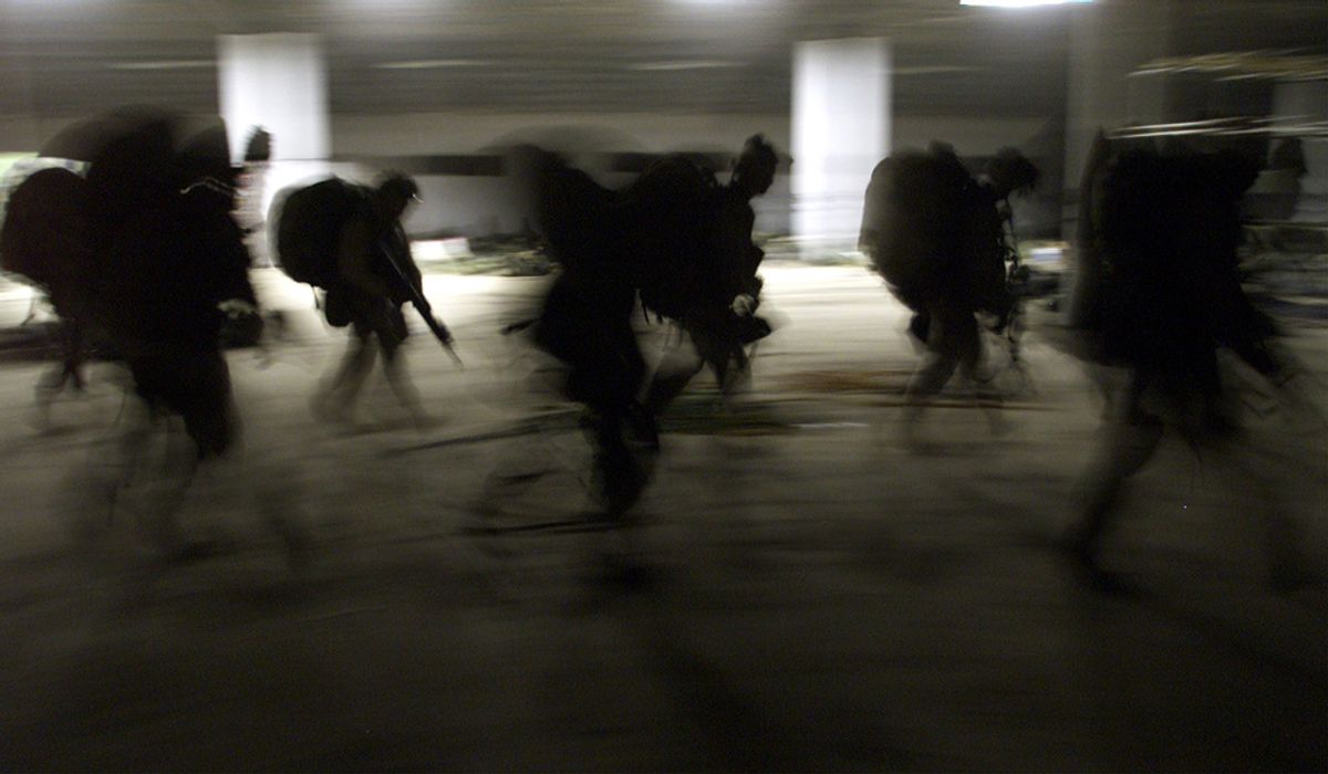 United States Marines from Bravo Co. of the 15th MEU (Marine Expeditionary Unity) march into a barracks in full battle gear as they arrive early November 29, 2001 at the US Marines forward base in southern Afghanistan. [Already hemmed into a shrinking swath of mountain and desert by nearly eight weeks of U.S. bombing and ground offensives by their Afghan foes, the Taliban now face another threat, hundreds of U.S. Marines pouring into a remote desert airstrip within striking distance of Kandahar, their spiritual cradle.]  (Â© Jim Hollander / Reuters)