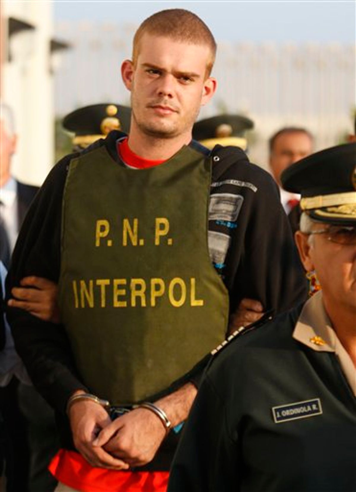 Dutch citizen Joran Van der Sloot, top, is escorted by police officers outside a Peruvian police station, near the border with Chile in Tacna, Peru, Friday, June 4, 2010. Chilean police have turned over van der Sloot,  murder suspect in Sunday's killing of 21-year-old Stephany Flores,  to Peruvian authorities at the countries' border. Van der Sloot was previously arrested in the 2005 disappearance of U.S. teen Natalee Holloway, but later released by Dutch authorities. (AP Photo/Karel Navarro) (AP)