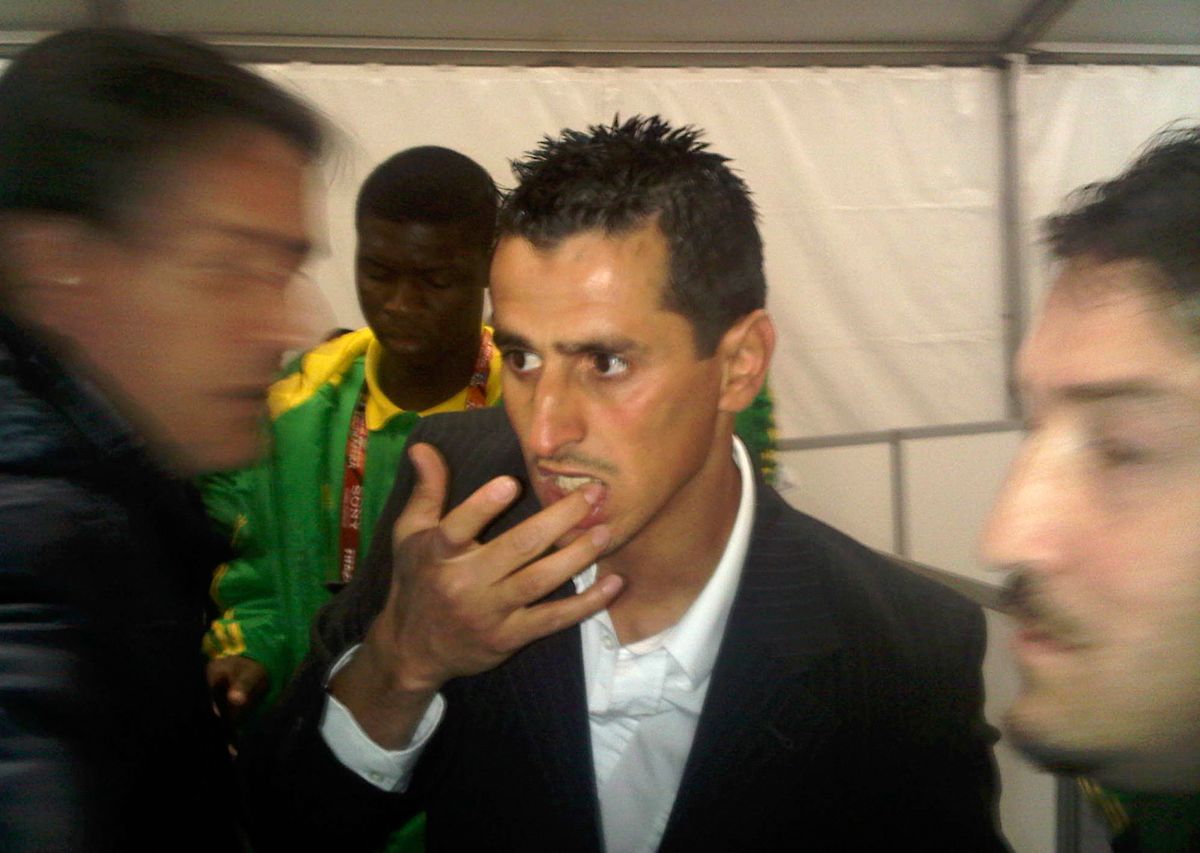 Algeria striker Rafik Saifi wipes his mouth in the mixed zone at Loftus Versfeld in Pretoria, South Africa, after the Algeria against United States in a World Cup soccer match Wednesday June 23, 2010. Saifi  has been involved in an altercation with a journalist after his team was eliminated from the World Cup. The incident following Wednesday's 1-0 loss to the United States happened at Loftus Versfeld. A female reporter from an Algerian publication was heard shouting at Saifi, who left the stadium holding his lip and refusing to respond to questions. (AP Photo/Rob Harris) (Rob Harris)