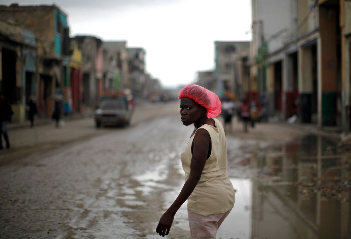 A woman crosses a street in downtown Port-au-Prince February 26, 2010. Seasonal rains and hurricanes spell trouble for Haiti in the best of times, but with hundreds of thousands of people living in flimsy makeshift shelters after last month's earthquake, this year the dangers are much greater.  REUTERS/Carlos Barria (HAITI - Tags: DISASTER ENVIRONMENT) (Â© Carlos Barria / Reuters)