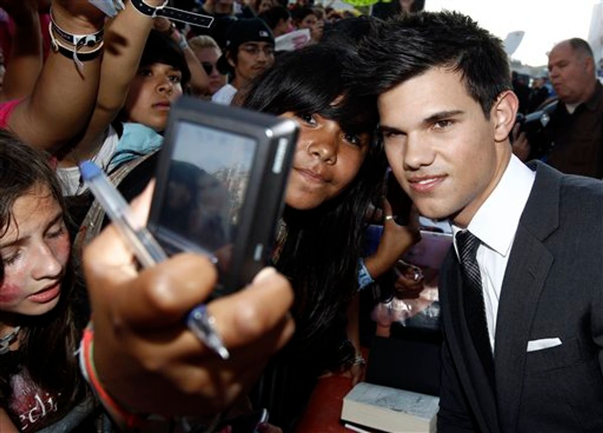 Taylor Lautner takes a photograph with a fan as he arrives at the premiere of "The Twilight Saga: Eclipse" on Thursday, June 24, 2010 in Los Angeles.  (AP Photo/Matt Sayles) (AP)