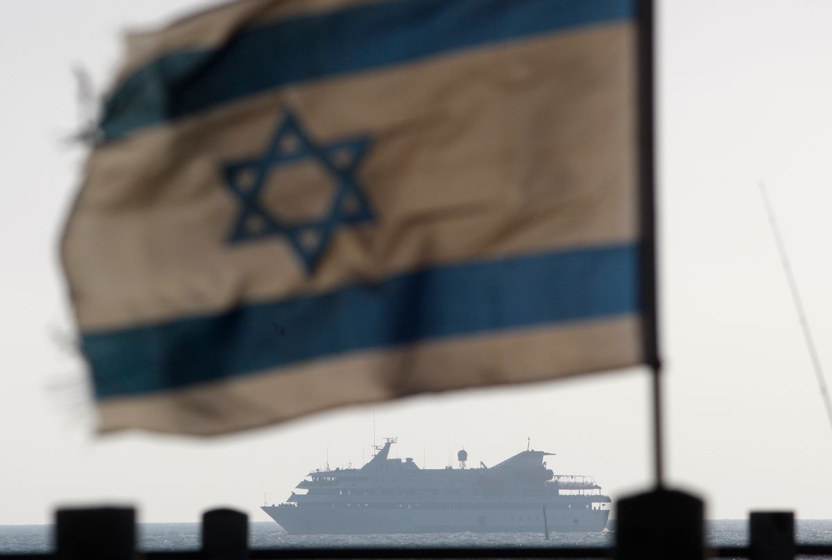 An Israeli flag flutters in the wind as a naval vessel (not seen) escorts the Mavi Marmara, a Gaza-bound ship that was raided by Israeli marines, to the Ashdod port May 31, 2010. Israeli marines stormed the Turkish aid ship bound for Gaza on Monday and 10 pro-Palestinian activists were killed, triggering a profound diplomatic crisis. REUTERS/Amir Cohen (ISRAEL - Tags: POLITICS CIVIL UNREST IMAGES OF THE DAY) (Reuters)