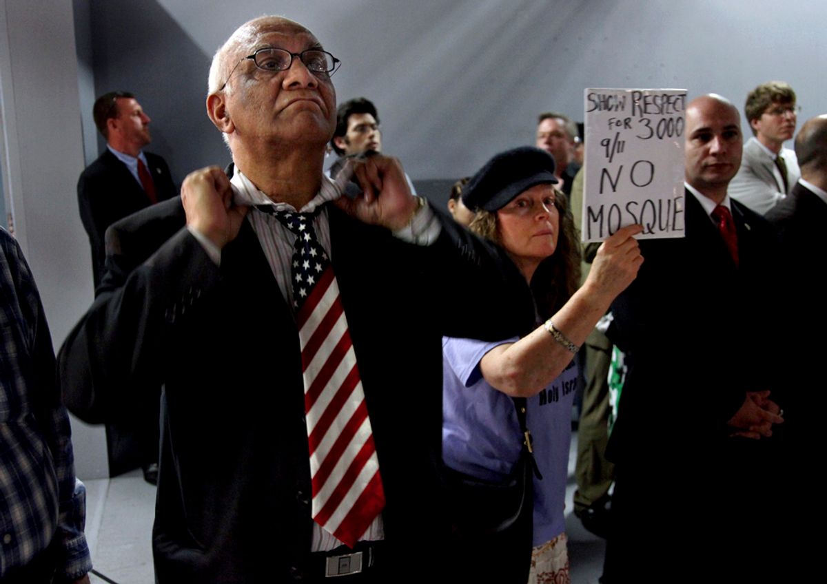 Arish Sahani, left, of New York, puts on an American Flag tie, and Linda Rivera, right, of New York, stand in opposition as groups planning a proposed mosque and cultural center near Ground Zero in Lower Manhattan to be named Cordoba House showed and spoke about their plans for the center at a community board meeting in New York Tuesday, May 25, 2010. Community members both for and against the plan spoke during the meeting.  (AP Photo/Craig Ruttle) (Craig Ruttle)