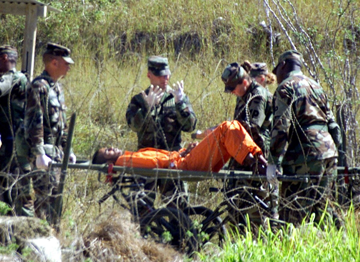 Military Police at camp X-Ray on the Naval Base at Guantanamo Bay,
Cuba, bring a detainee, who arrived at the camp injured, from an
interigation room after questioning February 2, 2002. The U.S. military
finished construction of a temporary prison camp on the U.S. Navy base
in Guantanamo Bay, Cuba, on Saturday, and can now more than double its
population of Taliban and al Qaeda prisoners, camp officials said.
REUTERS/Marc Serota

JP  (Reuters)