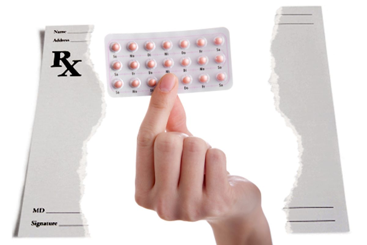 Female hand holding contraceptives against a white background