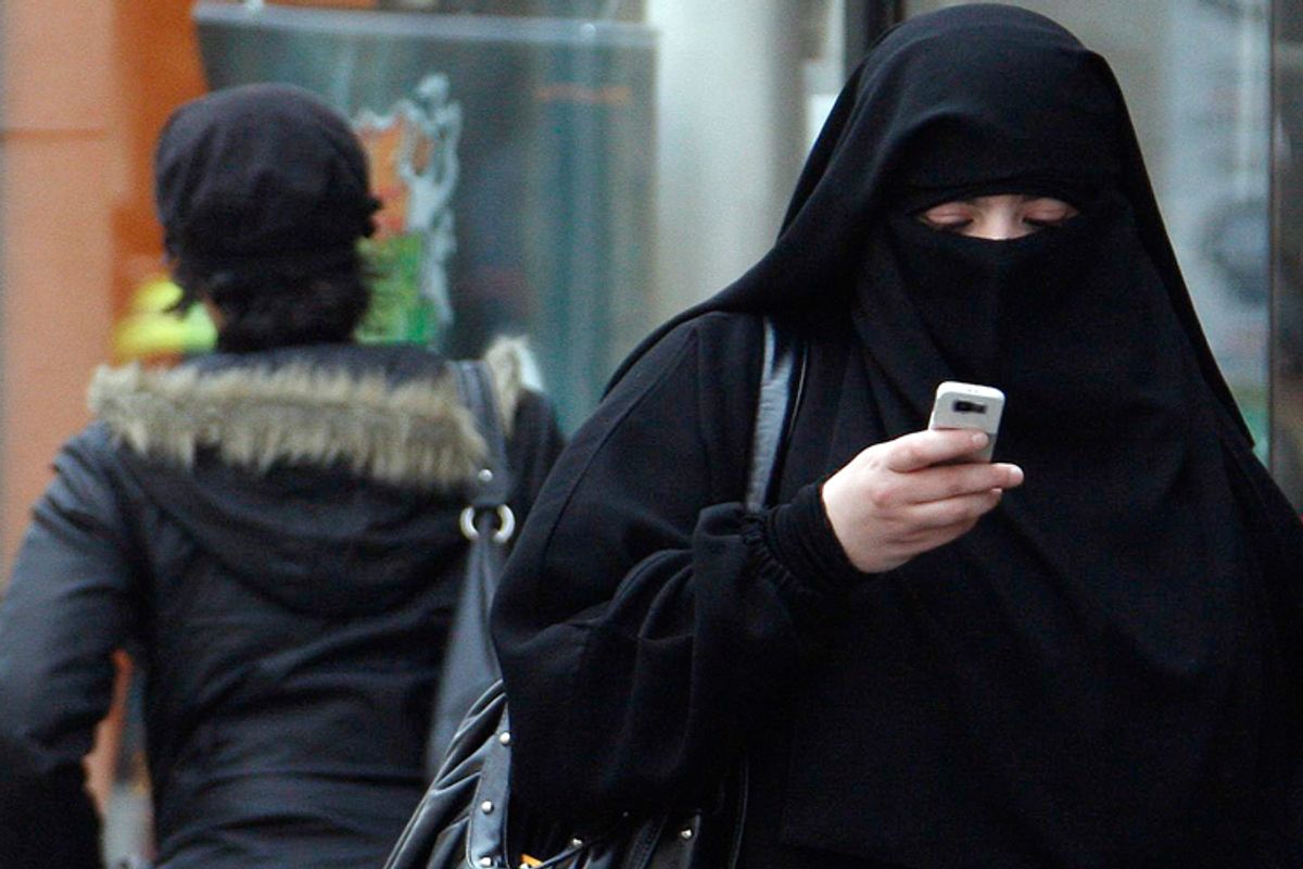 A woman wears a burqa as she walks on a street in Saint-Denis, near Paris, in April.