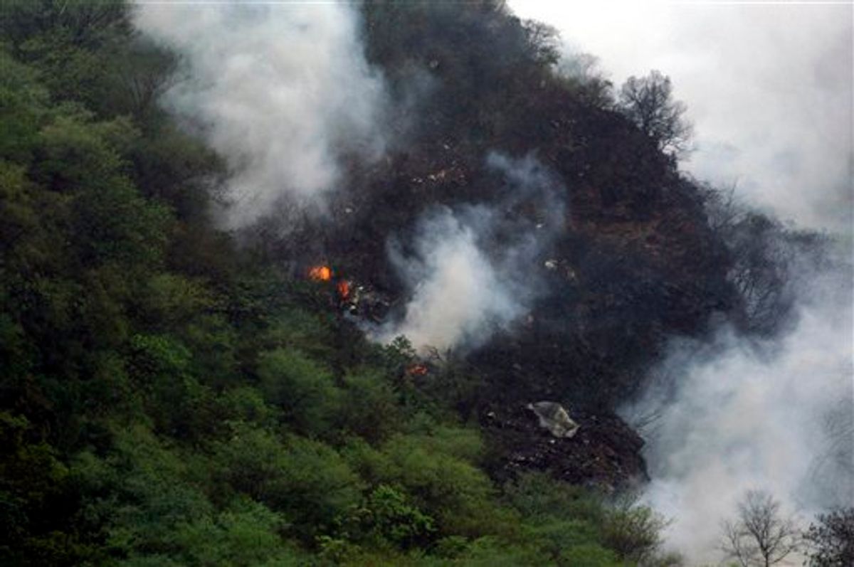 In this photo released by China's Xinhua News Agency, smoke rises from the site of a plane crash near Islamabad, Pakistan, Wednesday, July 28, 2010. The passenger jet carrying 152 people crashed into the hills surrounding Pakistan's capital amid rain Wednesday, officials said. According to a Pakistani government official over two dozen bodies have been recovered from the site, but many more were feared dead, while several passengers have been rescued. (AP Photo/Xinhua, Zeeshan Iyazi) NO SALES (AP)