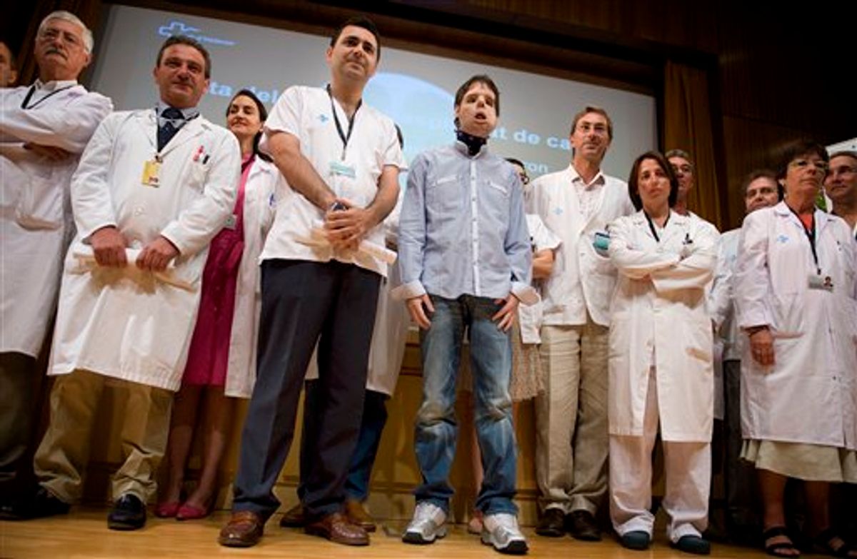 Oscar,center, a man who underwent a full-face transplant in April, poses beside Dr. Joan Barret, fourth from left, and surrounded by doctors as he appears in public for the first time in a news conference at the Vall d'Hebron Hospital in Barcelona, Spain, Monday, July 26, 2010. A 30-member medical team led by the Spanish doctor Juan Barret carried out a full-face transplant, giving a young man who lost his in an accident a new nose, skin, jaws, cheekbones, teeth and other features. (AP Photo/David Ramos) (AP)