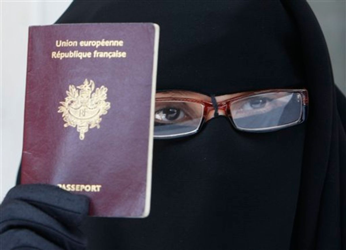 France's Najat shows her European passport, as dressed in a niqab, she addresses reporters during a press conference in Montreuil, east of Paris, Tuesday May 18, 2010. The French government will examine Wednesday,  a proposed bill forbidding burqa-style Islamic veils that cover the face, on the grounds that they do not respect French values or women's dignity.(AP Photo/Remy de la Mauviniere) (AP)