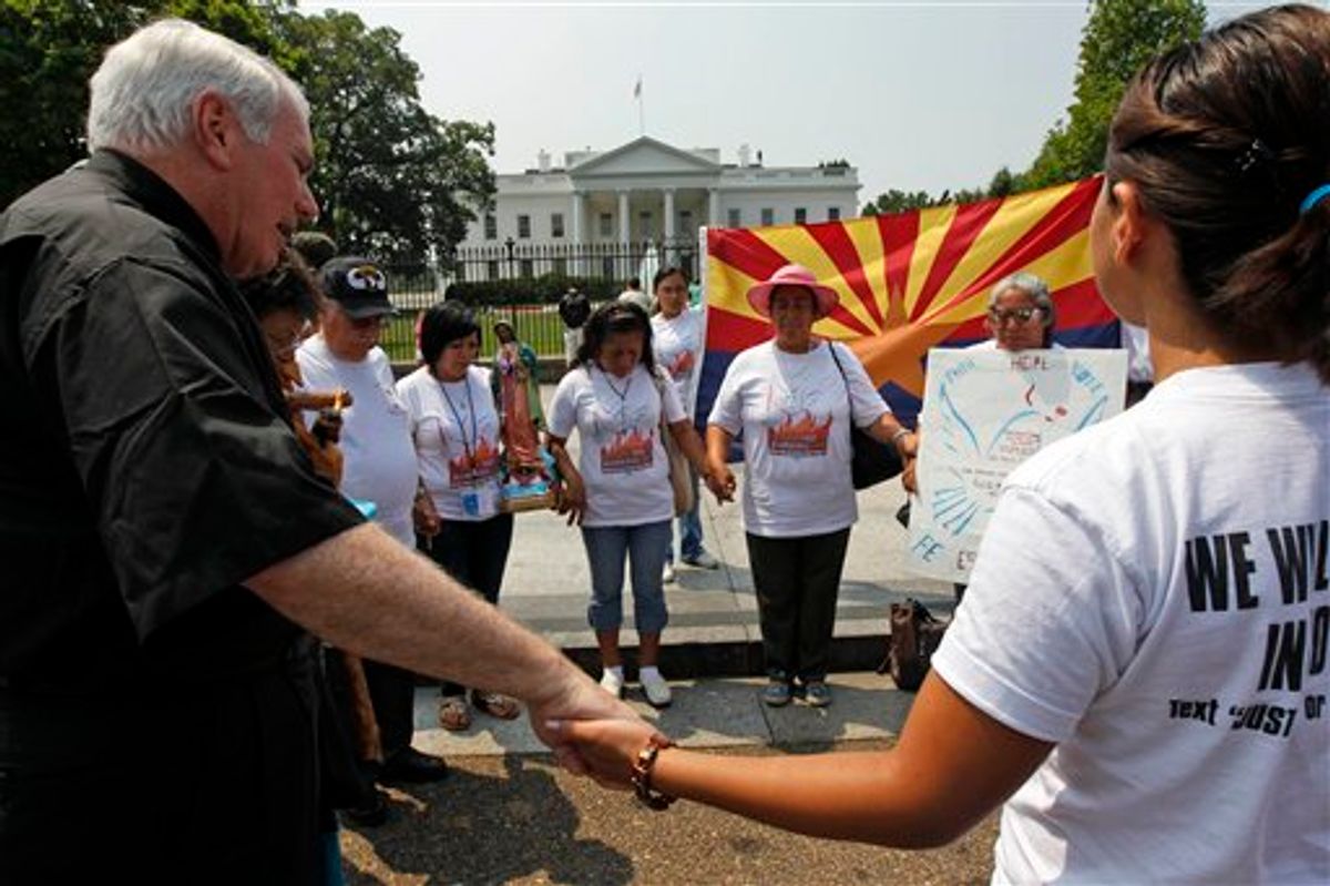Hispanic community members, some from Phoenix, hold hands in prayer to protest against SB1070, Arizona's immigration law, during a vigil in front of the White House in Washington Wednesday, July 7, 2010.(AP Photo/Alex Brandon)      (AP)