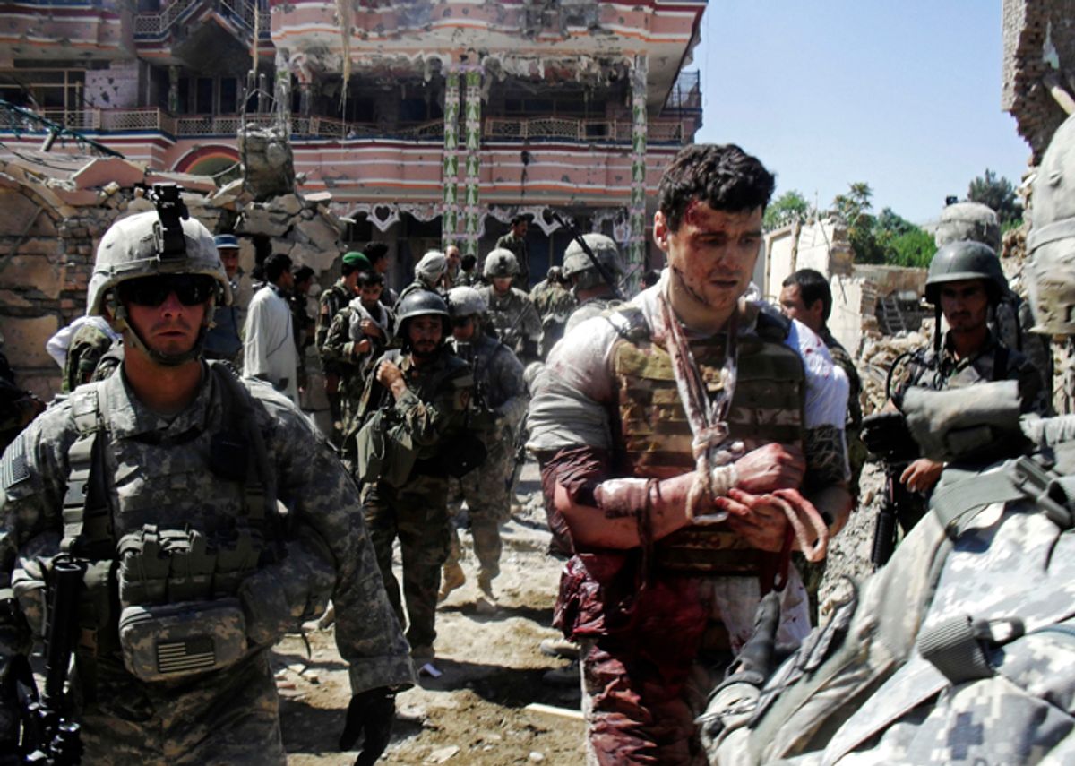U.S. soldiers escort a wounded foreign contractor at a USAID compound in Kunduz, north of Kabul, Afghanista, Friday, July 2, 2010 after it was stormed by militants wearing suicide vests. Six suicide bombers attacked the compound Friday in northern Afghanistan, killing at least four people and wounding several others, officials said.   (AP Photo) (Anonymous)