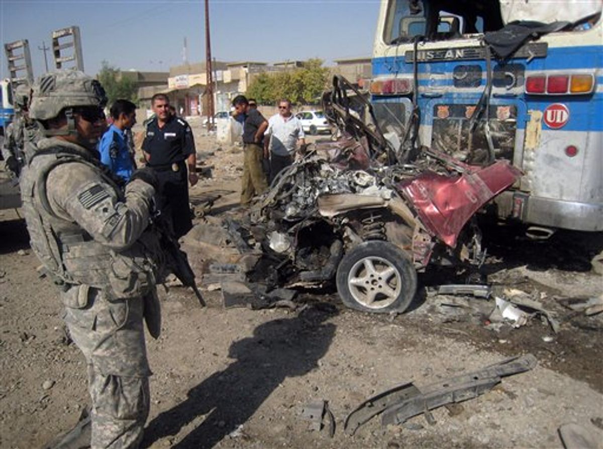 A U.S. Army soldier and Iraqi police stand at the site of a bombing in Kirkuk, 290 kilometers (180 miles) north of Baghdad, Iraq, Wednesday, Aug. 25, 2010. A string of attacks targeting Iraqi security forces on Wednesday left several people dead and scores wounded, police and hospital officials said the day after the number of American soldiers in the country fell bellow 50,000.(AP Photo/Emad Matti)  (AP)