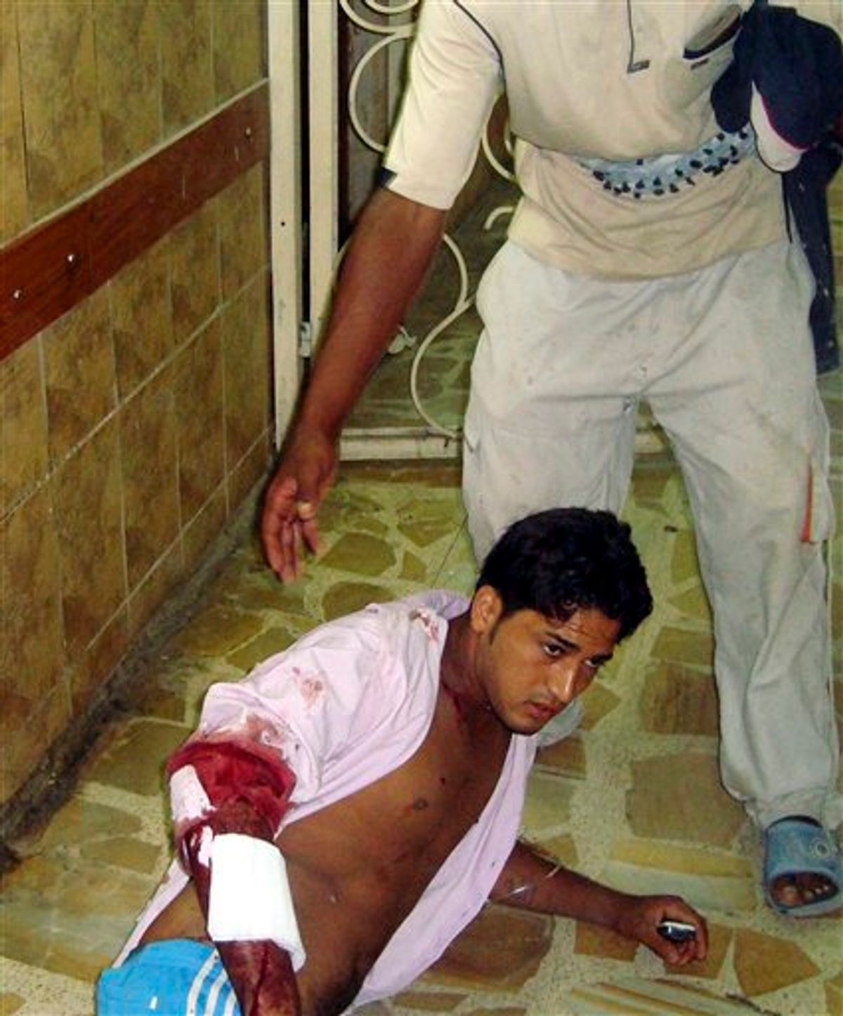 A victim of a suicide attack waits for a doctor on the floor of the emergency room of a hospital in Baghdad, Iraq, Tuesday, Aug. 17, 2010. A suicide bomber blew himself up Tuesday among hundreds of army recruits who had gathered near a military headquarters in central Baghdad killing and wounding dozens of them. (AP Photo)  (AP)