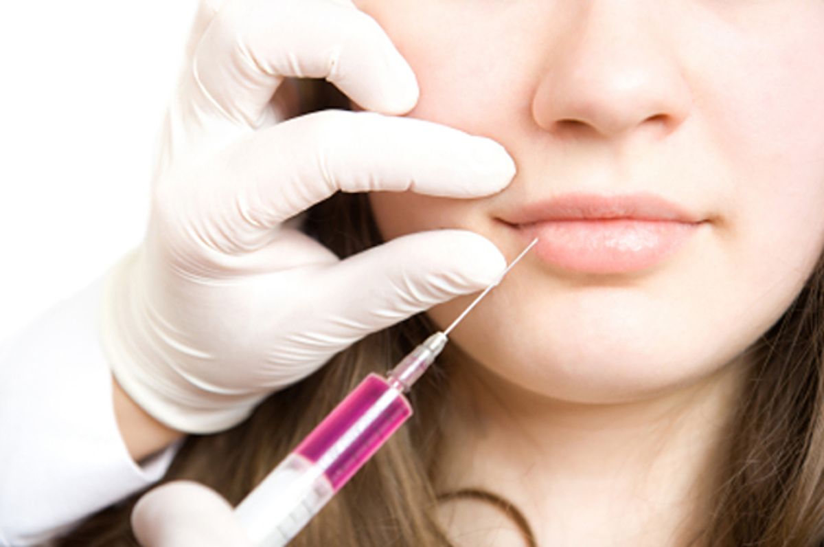 Doctor making injection in lips of young woman (Vadim Ponomarenko)