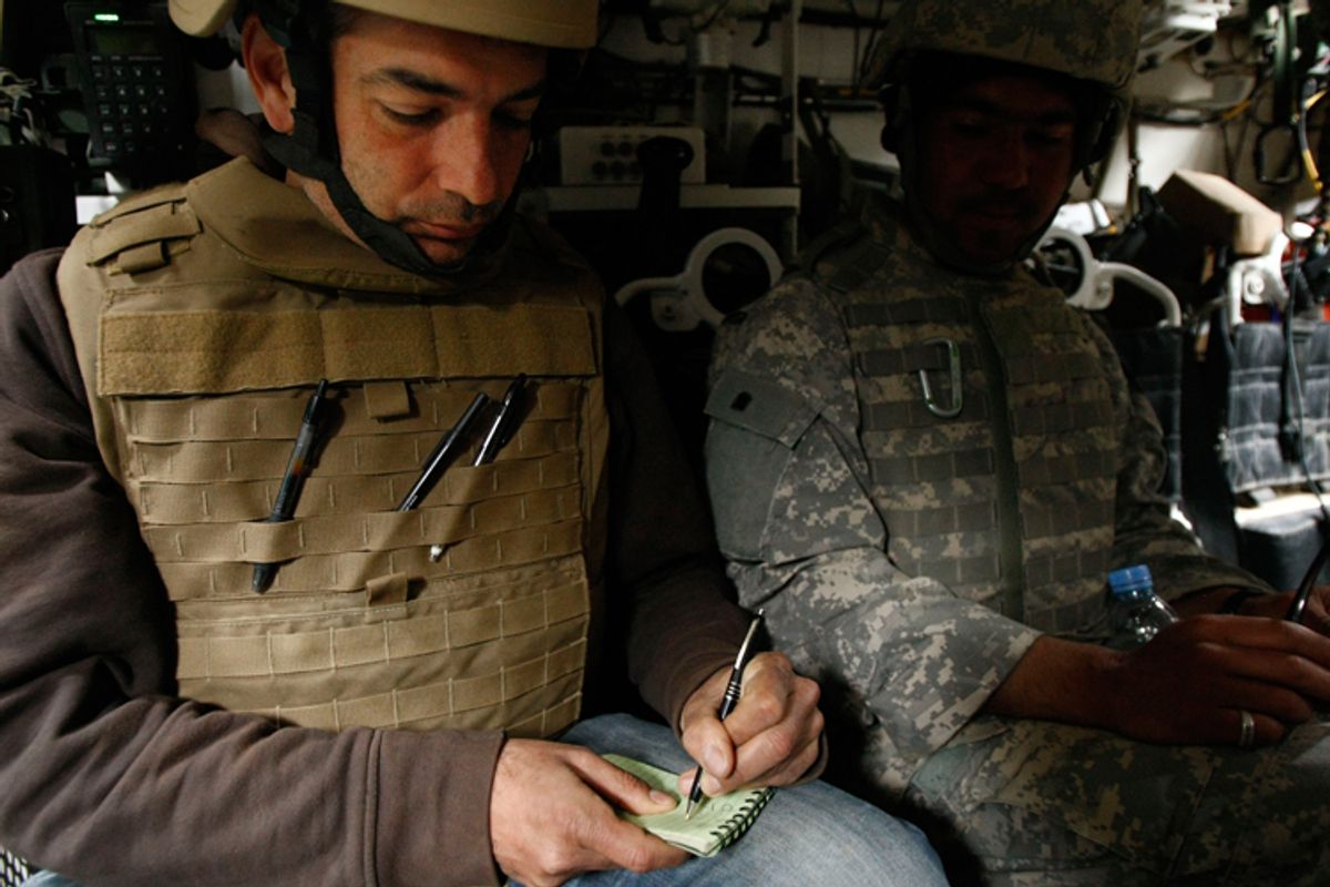 A reporter takes notes inside an armored vehicle during a ride with U.S. soldiers in southern Afghanistan.
