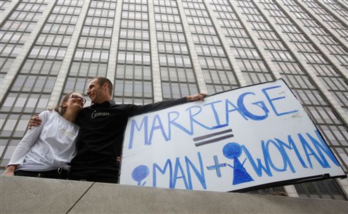 Nadia Chayka, left, and her fiance Luke Otterstad, both proponents of Proposition 8, hold up a sign outside of the Phillip Burton Federal Building in San Francisco, Wednesday, Aug. 4, 2010. The first word on whether California's same-sex marriage ban can survive scrutiny under the U.S. Constitution is expected to come down Wednesday when a federal judge issues his ruling in a landmark case challenging the voter-approved Proposition 8 as an unlawful infringement on the civil rights of gay men and lesbians. Attorneys on both sides have said appeals are certain if Chief U.S. Judge Vaughn Walker does not rule in their favor. (AP Photo/Jeff Chiu) (AP)