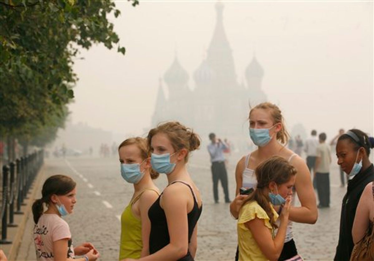 Young American tourists, no name or details given, brave the thick blanket of smog covering Moscow as they visit the Red Square, Sunday, Aug. 8, 2010, with St,Basil's cathedral in the background. A suffocating smog from wildfires hung over the Russian capital, raising the concentration of dangerous pollutants to an unprecedented new high as exasperated residents donned masks and dozens of flights were delayed or diverted at the city's airports. (AP Photo/Pavel Golovkin) (AP)