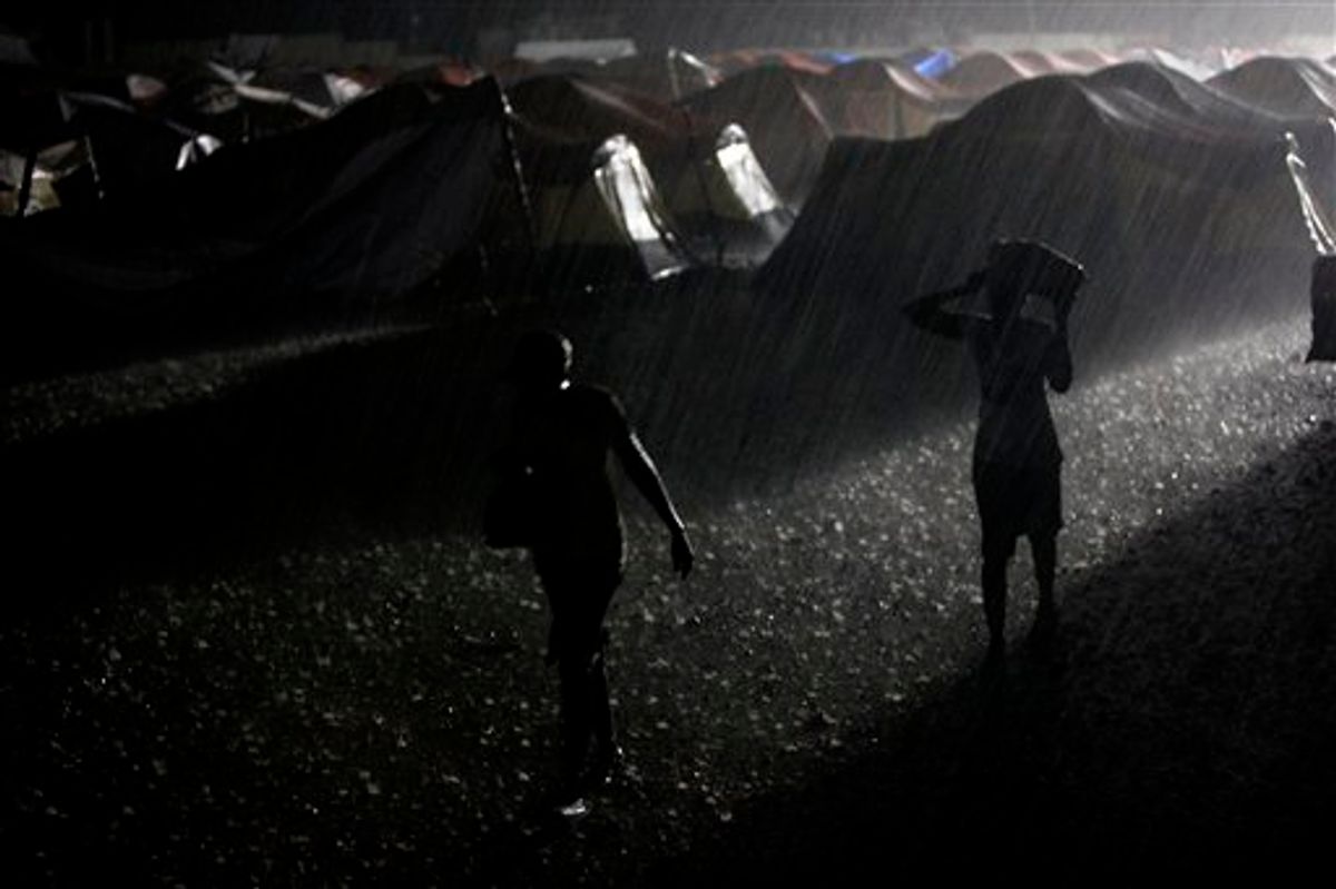 Women walk under heavy rain at a camp for earthquake displaced people in Port-au-Prince, Friday, May 21, 2010.(AP Photo/Esteban Felix)  (AP)