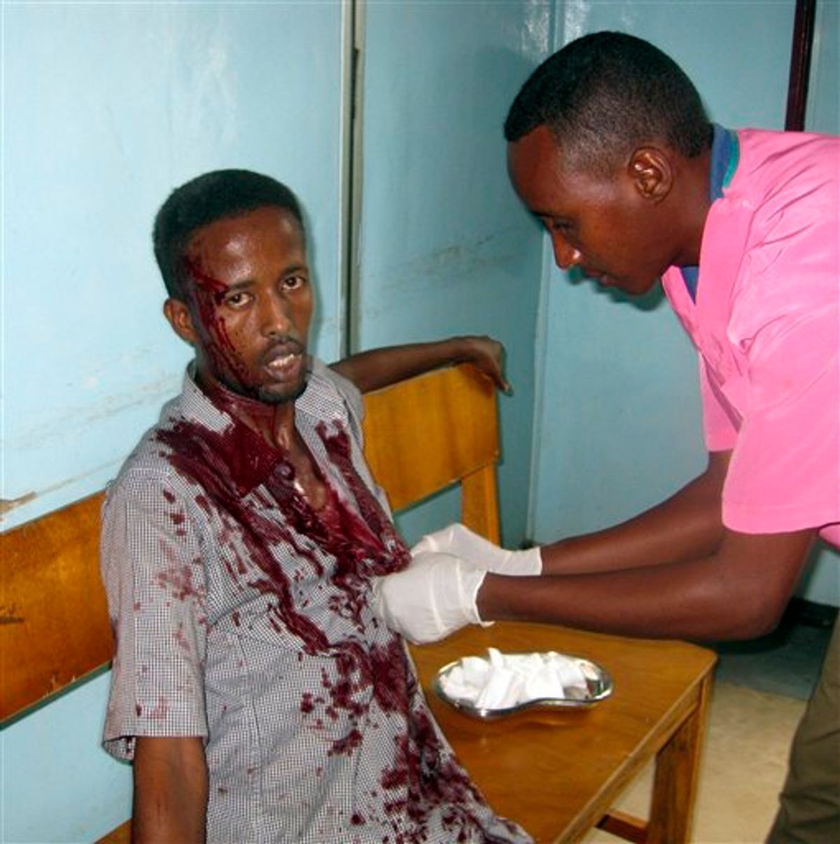 A nurse at Medina hospital treats a wounded civilian,at Medina hospital, Mogadishu, Somalia, Tuesday, Aug. 24, 2010. after he was wounded by mortar shrapnel during fighting between Somali insurgents and African Union troops. A suicide bomber and gunmen stormed a hotel in Somalia's capital on Tuesday, killing at least 15 people including members of parliament in an attack that set off an hour-long gun battle, a military spokesman and a witness said. (AP Photo/ Mohamed Sheikh Nor)  (AP)