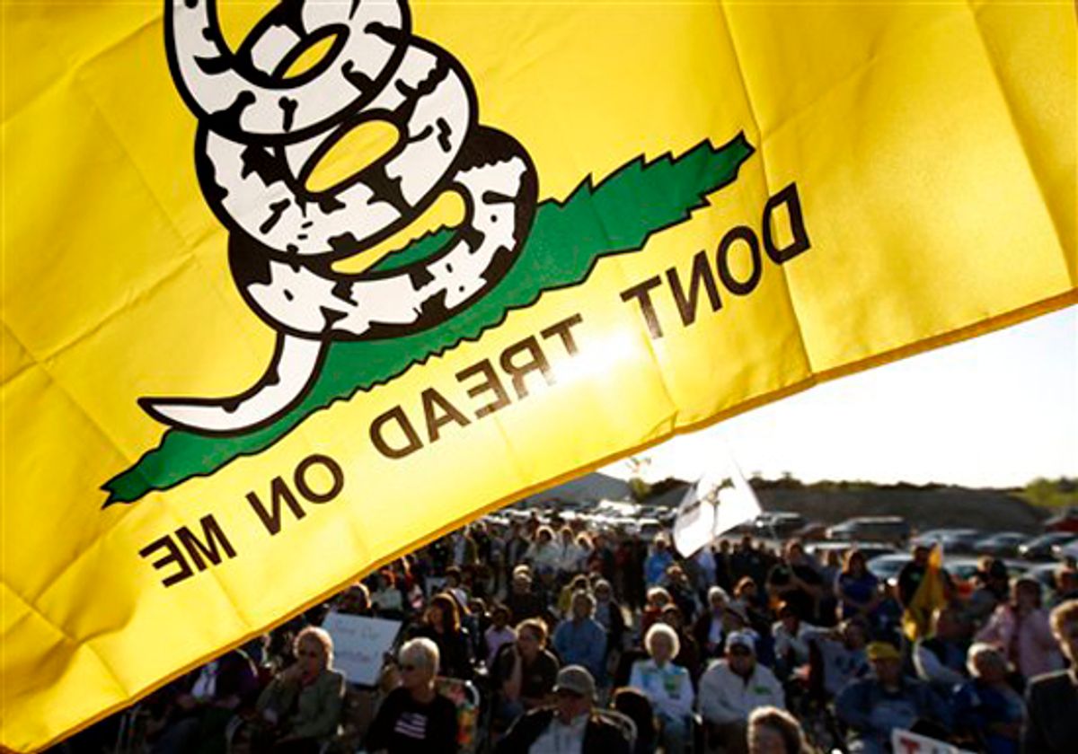 A Don't Tread On Me flag flies over protesters during a rally at Leo O'Laughlin Inc. on the eve of President Barack Obama's visit to Macon, Mo. Tuesday evening, April 27, 2010, in Macon. The protest was organized by the Missouri Republican Party and a tea party group called the Macon County Patriots. (AP Photo/Patrick T. Fallon) (Patrick Fallon)