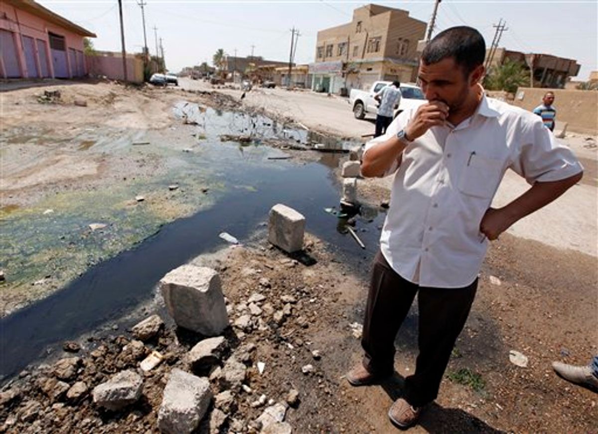 In this Sunday, Aug. 15, 2010 photo, a man stands in a sewage-filled street in Fallujah, Iraq, 40 miles (65 kilometers) west of Baghdad. The Fallujah waste water treatment system is almost finished _ at a cost of more than three times the original estimate and four years past the initial deadline. The sewage facility is among hundreds of projects funded by U.S. taxpayers that remain abandoned or incomplete, wasting more than $5 billion, according to auditors. (AP Photo/Hadi Mizban) (AP)