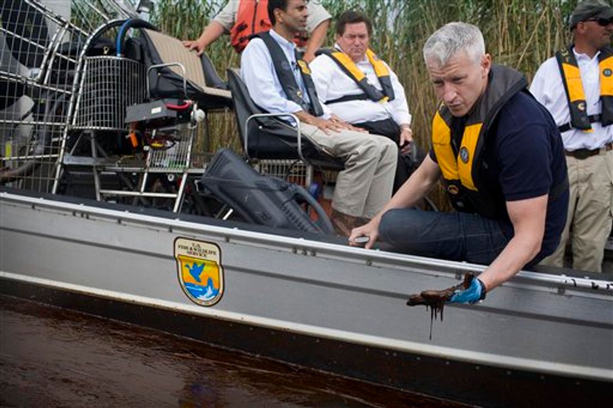 FILE - In this May 26, 2010 publicity image released by CNN, CNN's Anderson Cooper, right, inspects the oil spill during a tour with Louisiana Gov. Bobby Jindal, background left, of the contaminated areas in Blind Bay, La. (AP Photo/CNN, Shaul Schwarz)        (AP)
