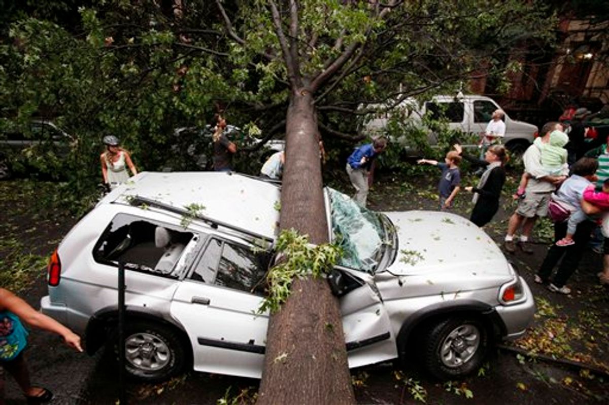 Residents in the Park Slope neighborhood in the Brooklyn borough of New York circle around a car crushed by a fallen tree, Thursday, Sept. 16, 2010. A brief but severe storm has swept through New York City, uprooting trees and damaging cars. (AP Photo/Mark Lennihan) (AP)