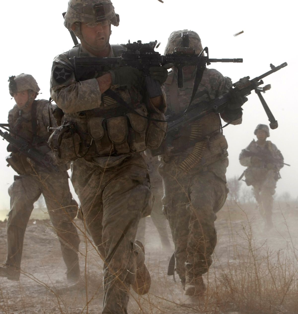 A U.S. soldier returns fire as others run for cover during a firefight with insurgents in the Badula Qulp area, West of Lashkar Gah in Helmand province, southern Afghanistan, Feb. 14, 2010.