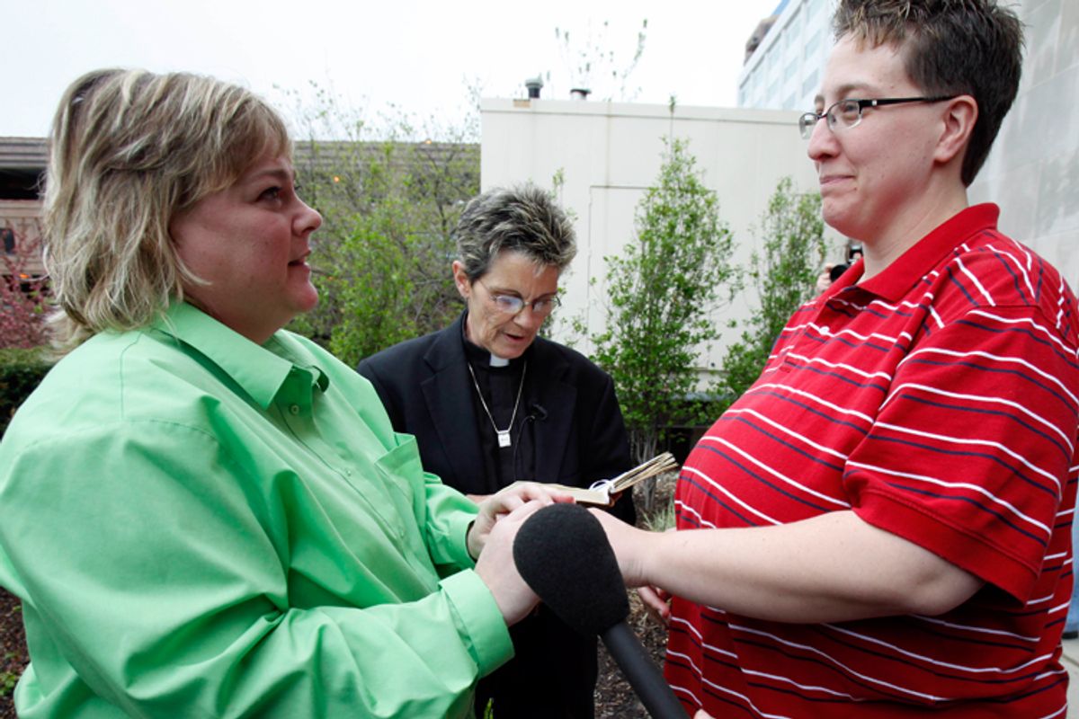 Shelley Wolfe, left, holds hands with Melisa Keeton as Rev. Peg Esperanza, center, performs their wedding ceremony outside the Polk County administrative building on April 27, 2009, in Des Moines, Iowa.     
