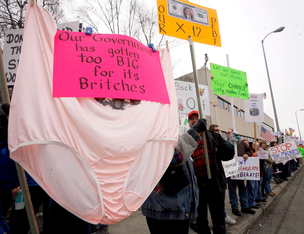 Demonstrators hold up a sign that reads "Our government has gotten too big for its britches" outside the federal building in Anchorage, Alaska.
